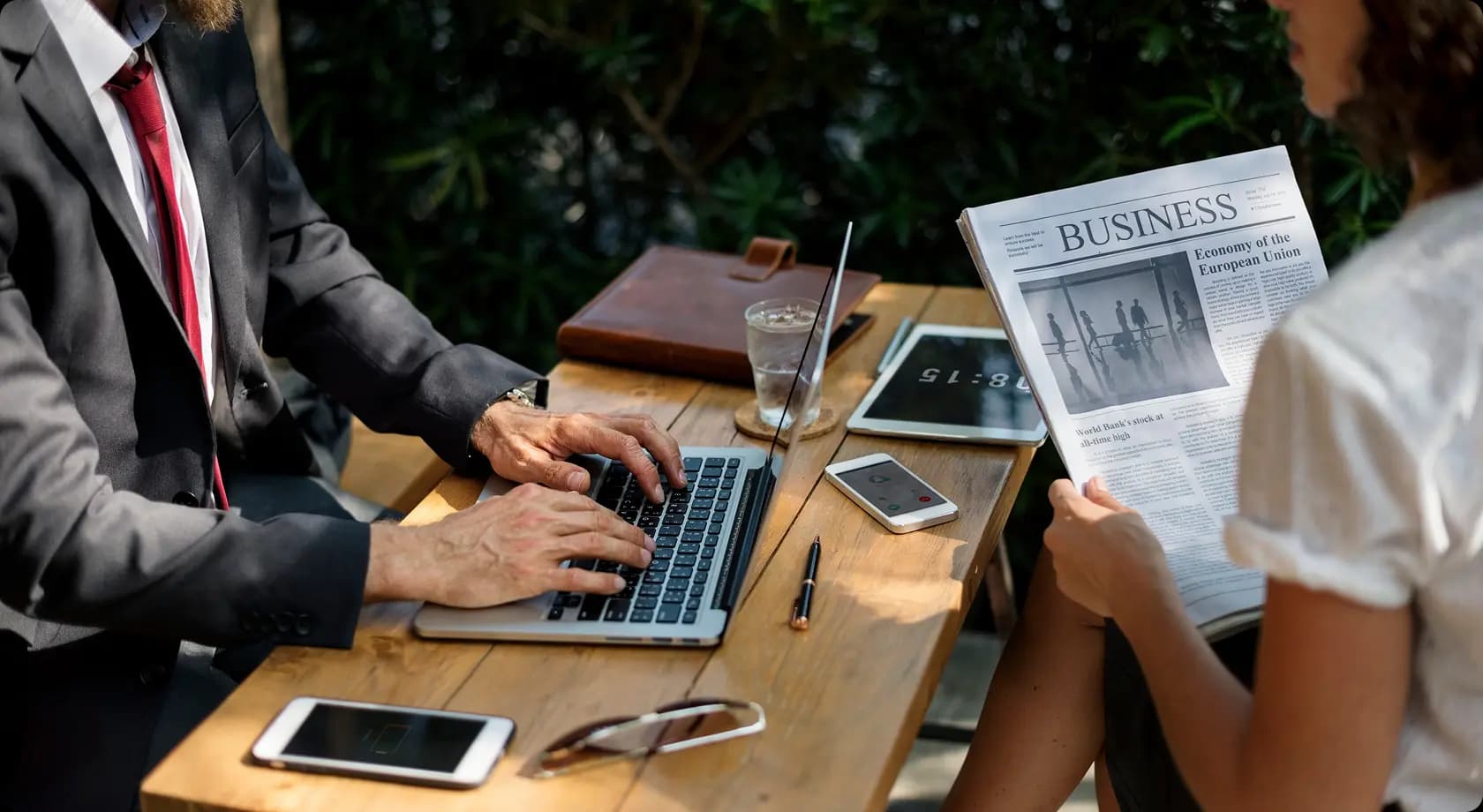 People reviewing business news and working on a laptop